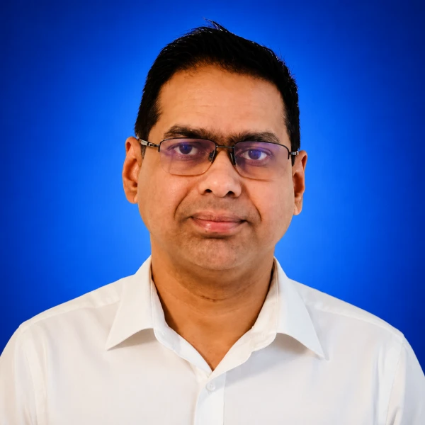 Portrait of a man with glasses in a white shirt against a blue background. 1