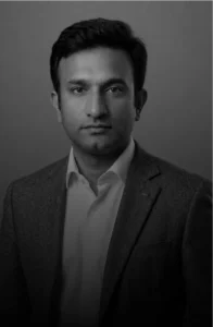 Black-and-white head-and-shoulders portrait of a man in a suit looking at the camera.